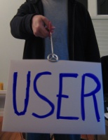 Me using tongs to hold a sheet of paper with the word "User" written on it